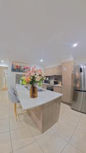 a kitchen with a table with a vase of flowers on it at Canaan Oasis in Pimpama