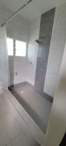 a bathroom with a shower with a mirror at Lord's Hands Guesthouse Hotel in Winneba +34 photos