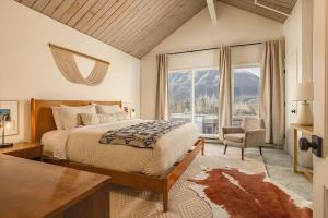 a bedroom with a bed and a chair and a window at Alpine Charm By Alyeska Sleeps 6 in Girdwood