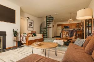 a living room with a couch and a table at Alpine Charm By Alyeska Sleeps 6 in Girdwood
