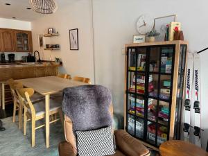 a dining room with a table and chairs and a clock at Alpine Charm By Alyeska Sleeps 6 in Girdwood