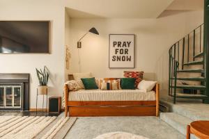a living room with a couch and a staircase at Alpine Charm By Alyeska Sleeps 6 in Girdwood +38 photos