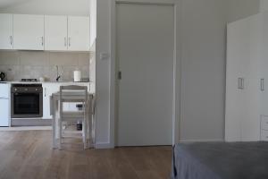 a kitchen with white cabinets and a table and a chair at Estudio Robusto in Monte do Valão