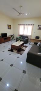 a living room with a couch and a table at Lord's Hands Guesthouse Hotel in Winneba