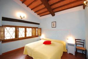 LuianoにあるFattoria di Larnianoのベッドルーム1室(赤い枕付きのベッド1台付)