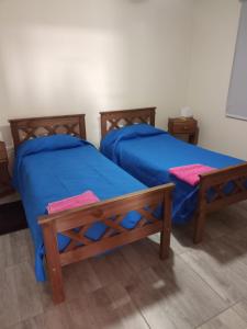 two beds with blue sheets in a room at El último Cartucho in Tandil +23 photos