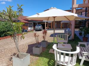 a table and two chairs and an umbrella at Renacer in Federación