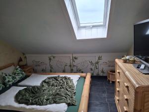 a bedroom with a bed with a green blanket on it at Ferienwohnung Anke Günther Dach in Bad Kissingen