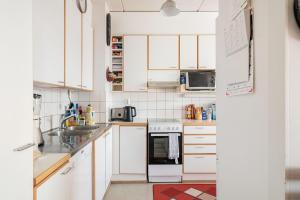 a white kitchen with white cabinets and appliances at Peace & Harmony in Espoo