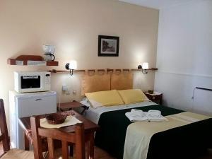 a bedroom with two beds and a table and a microwave at Renacer in Federación