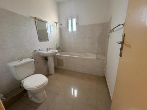 a bathroom with a toilet and a sink and a tub at Anta's House Sipres - Chambre calme et confortable in Dakar