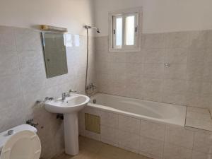 a bathroom with a sink and a tub and a toilet at Anta's House Sipres - Chambre calme et confortable in Dakar