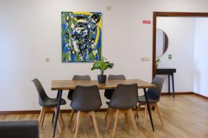 a dining room table and chairs with a painting on the wall at Casa do Simão Gaula in Santa Cruz