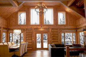 a dining room and living room in a log cabin at Belvedere sur le Lac Lodge in Sainte-Adèle