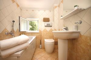a bathroom with a sink and a toilet and a sink at Apartments Katušić in Cavtat +129 photos