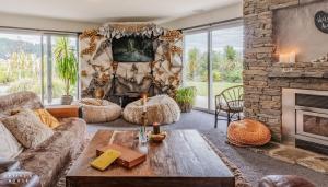 a living room with a fireplace and a stone wall at The Artist's House Wanaka in Luggate