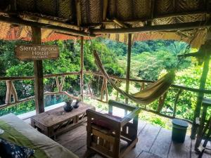 a hammock in a room with a view of the forest at Sierra Tayrona hostel in El Zaino