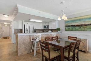 a kitchen and dining room with a table and chairs at Islander E 7011 Stunning oceanfront condo with pool & gym access in Fort Walton Beach