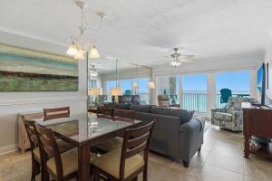 a dining room and living room with a couch and a table at Islander E 7011 Stunning oceanfront condo with pool & gym access in Fort Walton Beach