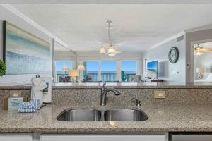 a kitchen with a sink and a view of the ocean at Islander E 7011 Stunning oceanfront condo with pool & gym access in Fort Walton Beach +34 photos