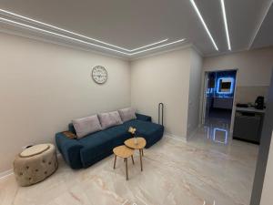 a living room with a blue couch and a table at WOT Rose Residence in Arad