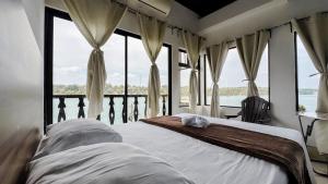 a bedroom with a bed in front of windows at La Posada De Don Jose in Flores