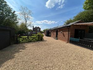 a driveway with a fence and a building at Cobblers Lodge in Somersham