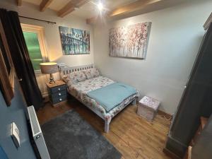 a small bedroom with a bed and a lamp at Cobblers Lodge in Somersham