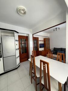 a kitchen with a table and chairs and a refrigerator at Recuncho de Corme, a 100 metros de la playa in Corme-Puerto