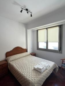 a bedroom with a bed with two white towels on it at Recuncho de Corme, a 100 metros de la playa in Corme-Puerto