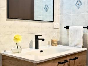 a bathroom sink with a vase of flowers and a mirror at Chalet San Primo in Castiglione dʼIntelvi