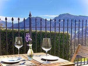 a table with two wine glasses and a bottle at Chalet San Primo in Castiglione dʼIntelvi