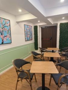 a waiting room with tables and chairs and plants at Le Jardin Lisbon in Lisbon