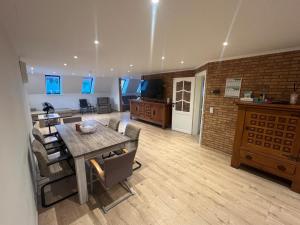 a living room with a dining table and a kitchen at Kampenhout appartement met terras en 4 slaap kamers in Kampenhout
