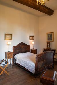 a bedroom with a bed with two tables and two lamps at Le Logis d'Equilly in Équilly