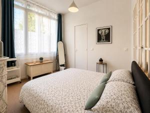 a bedroom with a bed and a window at Appartement calme et spacieux - Garage vélo in Saint-Quentin