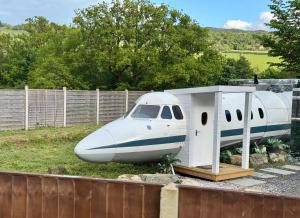 a plane sitting on the grass next to a fence at Alaya Airways in Dolgellau