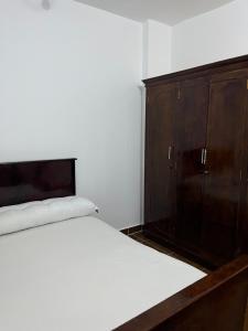 a bedroom with a bed and a wooden cabinet at Farida Nile view in Luxor