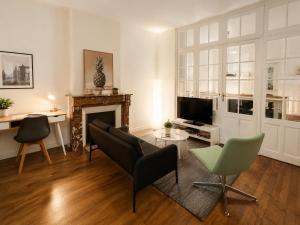 a living room with a couch and a fireplace at Appartement calme et spacieux - Garage vélo in Saint-Quentin