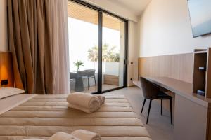 a hotel room with a bed and a desk and a window at Terradamare Suites in Monopoli +113 photos