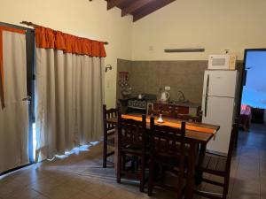 a kitchen with a wooden table and a refrigerator at El Rincón del Molle in Merlo