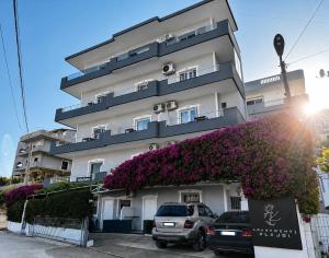 a building with cars parked in front of it at Apartments Klajdi in Sarandë