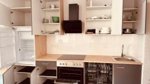 a kitchen with white cabinets and a stove top oven at Cozy & small apartment-Böblingen in Böblingen