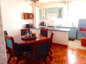 a kitchen with a wooden table and chairs in a room at Churlinsky Apartments in Eldoret