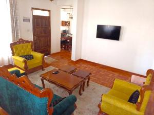 a living room with chairs and a table and a tv at Churlinsky Apartments in Eldoret