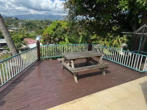 a picnic table on a wooden deck with a fence at Holiday Home in Lautoka