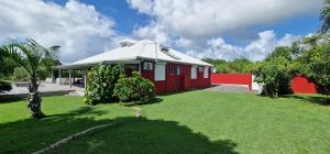 a red house with a white roof in a yard at Splendide villa de Courcelles 4 étoiles Piscine & jacuzzi in Saint-François