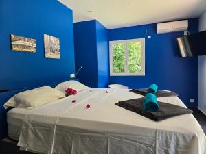a blue bedroom with a large bed with blue walls at Splendide villa de Courcelles 4 étoiles Piscine & jacuzzi in Saint-François +37 photos