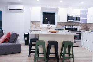 a kitchen with a island with four green stools at The View in French Village +12 photos