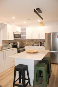 a kitchen with white cabinets and green bar stools at The View in French Village